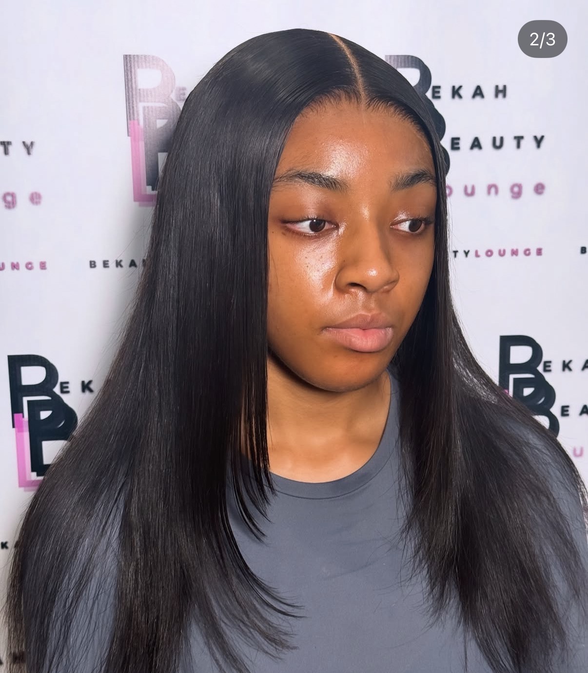 Client wearing a sleek straight middle-part install by Bekah